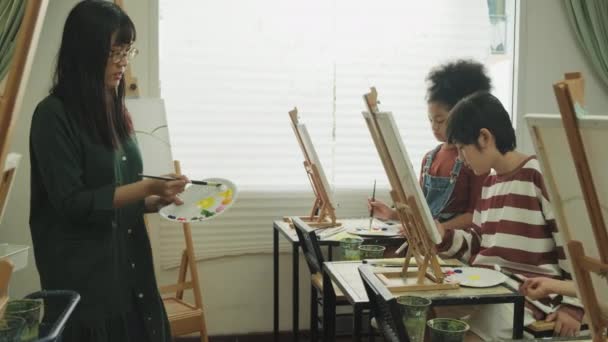 Grupa Wielorasowych Dzieci Uczących Się Azjatką Uczy Malarstwa Akrylowego Płótnie — Wideo stockowe