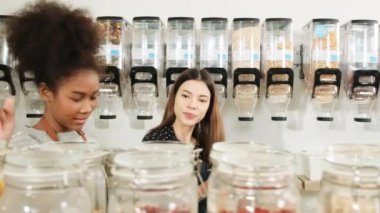 İki kadın esnaf, yeniden kullanılabilir konteynırlardaki doğal organik ürün stoklarını, sıfır atıkları, plastiksiz marketleri ve çevre dostu, sürdürülebilir iş yerlerini kontrol ediyor..