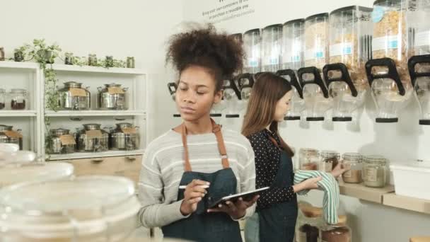 Två Unga Kvinnliga Butiksägare Arbetar Påfyllningsbutik Kontrollera Lager Ekologiska Produkter — Stockvideo