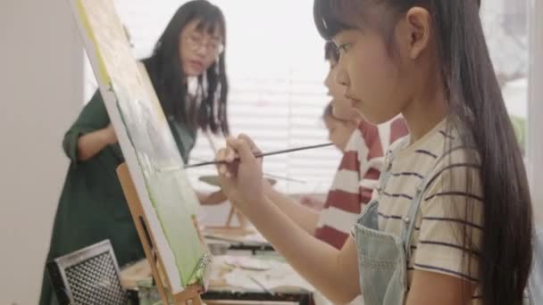 Азійська Дівчина Зосереджується Малюванні Акрилових Кольорів Полотні Багаторасовими Дітьми Художньому — стокове відео