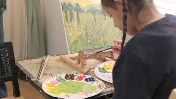 Dívka Soustřeďuje Akrylovou Barevnou Malbu Plátně Stojanu Učitelem Dětmi Třídě — Stock video