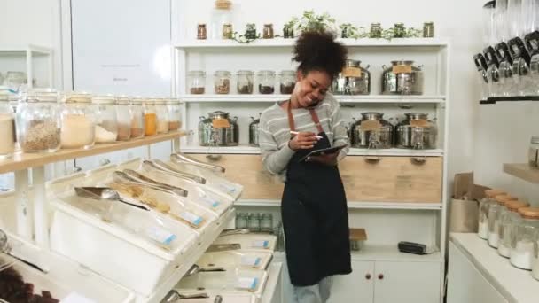 Een Zwarte Vrouwelijke Winkelier Werkt Navulwinkel Praat Mobiele Telefoon Met — Stockvideo