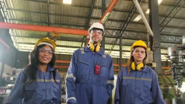 プロの工業労働者のチームは仕事の後を祝う 白人男性の生産技術者と女性の同僚はリラックスし 製造工場の機械の近くに金属製のレンチで手を上げます — ストック動画