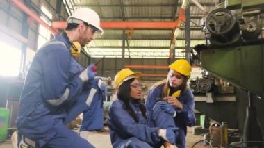 Endüstriyel metal üretiminde meydana gelen acı verici kazada, Afrikalı Amerikalı kadın işçi bacağını yaraladı, erkek mühendis ve iş arkadaşı makine fabrikasında ilk yardıma yardım etti.. 