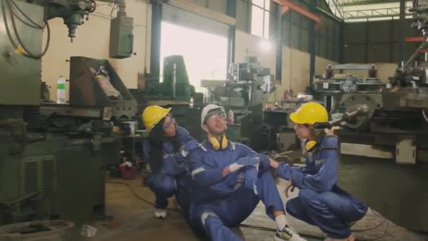 过度劳累的男性工业工程师工人精疲力竭 同事在制造业工厂帮助急救 安全制服和钢盔可以防止机械造成的金属加工事故 — 图库视频影像
