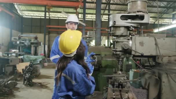 两名穿着保护和安全制服和硬礼帽的产业工人 男性经理和黑人同事在制造厂与金属加工机械一起工作 专业生产工程师小组 — 图库视频影像