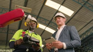 Bir Afrikalı Amerikalı mühendis, makine imalat fabrikasındaki müşterilere akıllı robotik silah kontrolü, endüstriyel sektördeki akıllı otomatik makineler ve gelecekteki teknolojiyi gösteriyor..