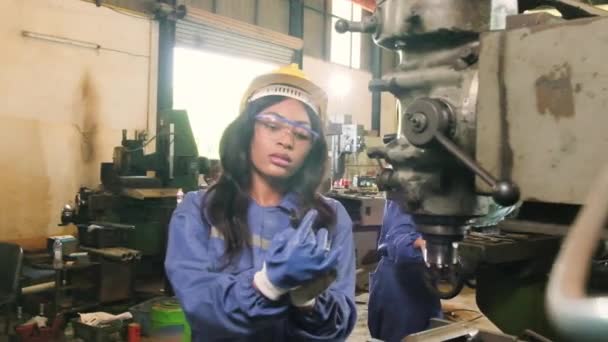 アフリカ系アメリカ人女性の労働者は保護と安全の均一性と硬度が製造工場の金属加工機での作業に疲れている プロの生産技術者職業 — ストック動画