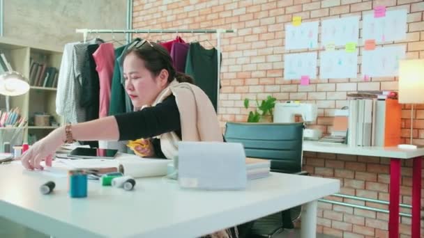亚洲中年女性时装设计师在工作室工作 为服装设计系列剪裁和选择带有草图的面料图案 专业精品裁缝店 — 图库视频影像