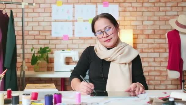 Portrait Mature Asian Female Fashion Designer Sits Studio Arms Crossed — Video