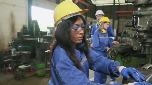 保護と安全の制服とハードハット 男性マネージャー および女性の同僚の産業労働者チームは 製造工場で金属加工機と協力しています プロの生産技術者 — ストック動画