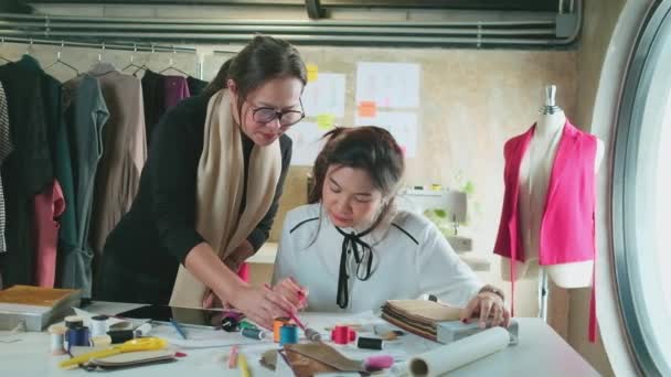 Ασιάτισσα Μεσήλικη Σχεδιάστρια Μόδας Διδάσκει Μια Νεαρή Έφηβη Εκπαιδευόμενη Ράφτη — Αρχείο Βίντεο