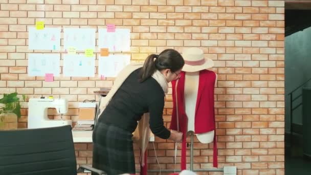 アジアの中年女性ファッションデザイナーは人形の形を測定し スケッチのアイデア 想像力のドレスのデザインコレクション プロのブティックテーラー中小企業起業家を描くことによってスタジオで動作します — ストック動画