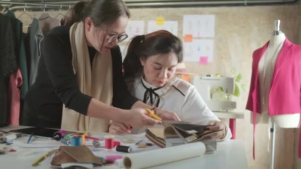 Asiatische Modedesignerin Mittleren Alters Unterrichtet Eine Junge Teen Auszubildende Schneiderin — Stockvideo