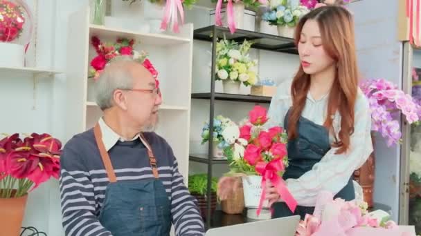 Азиатский Пожилой Владелец Цветочного Магазина Мужчина Обсуждает Молодой Красивой Сотрудницей — стоковое видео