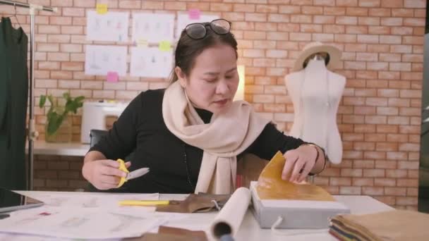 Азиатская Модельер Средних Лет Работает Студии Вырезая Выбирая Идеи Тканевых — стоковое видео