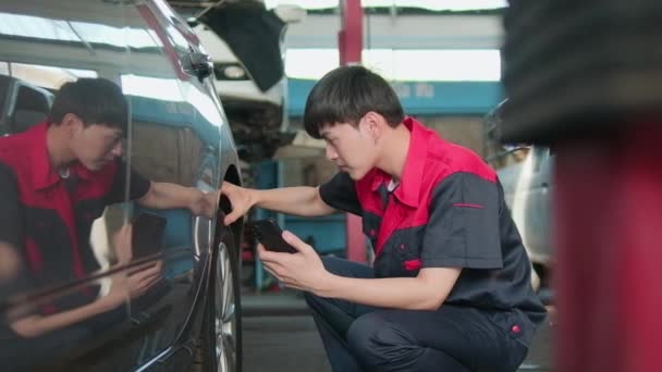 Młody Mężczyzna Azjatycki Profesjonalny Mechanik Samochodowy Sprawdza Ciśnienie Oponach Pomocą — Wideo stockowe