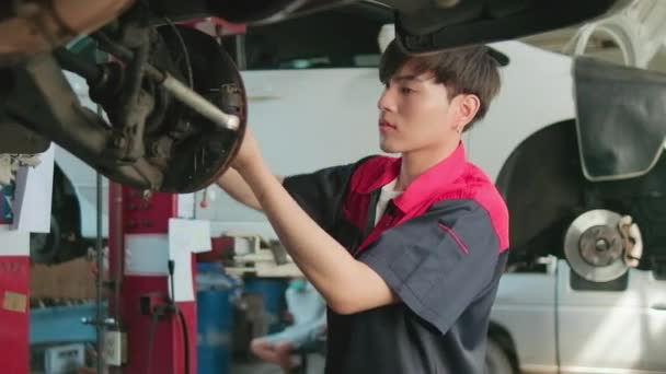 One Young Expert Asian Male Automotive Mechanic Technician Screwing Car — Stockvideo
