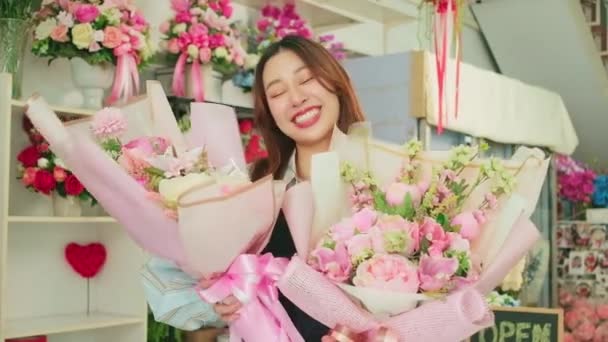 バレンタイン 幸せと明るい笑顔で受け取る美しい植物の花束を示す1つの陽気な女性花屋の労働者 カラフルな花の店で仕事を手配 中小企業の起業家の人 — ストック動画