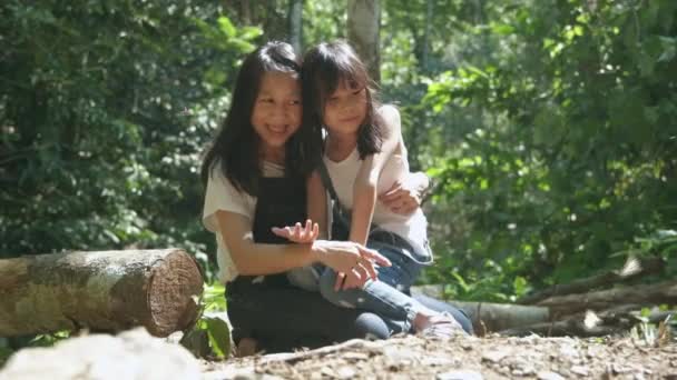 アジアのお母さんと女の子は蝶の多くの群れが飛んで明るく 美しい翼 国立公園の熱帯林の塩沼で食べ物を食べる 屋外学習体験 自然知識 — ストック動画