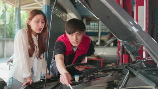 Trabalhador Mecânico Automotivo Masculino Explica Listas Verificação Para Cliente Asiático — Vídeo de Stock