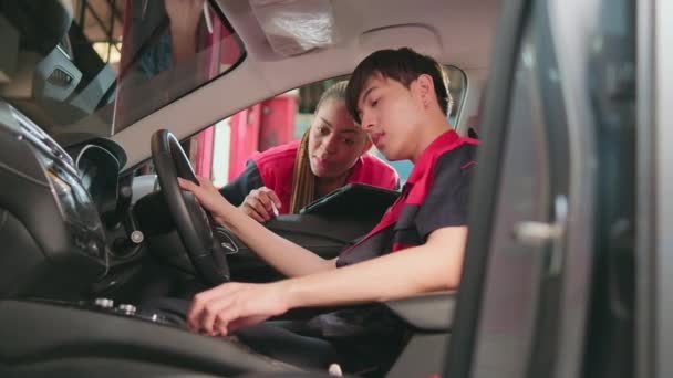 Genç Asyalı Erkek Otomotiv Teknisyeni Partneri Bakım Listesini Garajın Içinde — Stok video