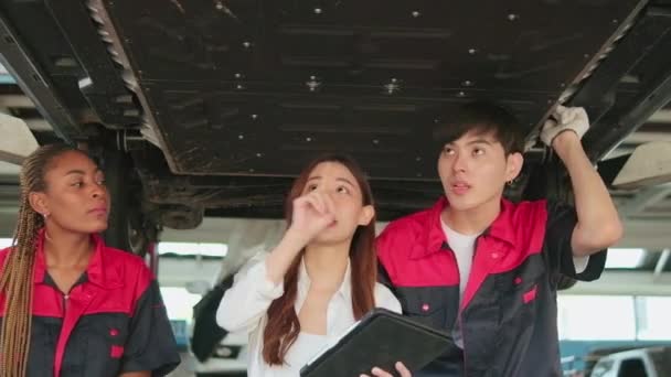 Junge Asiatische Autounternehmerin Diskutiert Mit Mechaniker Team Checkliste Untergestell Von — Stockvideo