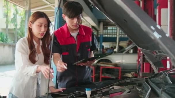 Mężczyzna Samochodowy Mechaniczny Pracownik Wyjaśnia Listy Kontrolne Azjatyckiego Klienta Naprawa — Wideo stockowe