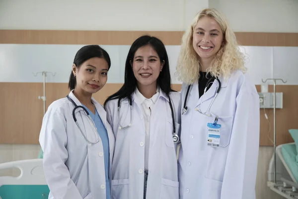 专业医护人员团队 3名身穿白色制服的女医生看着镜头 面带微笑 快乐地在医院诊所从事体力劳动 — 图库照片