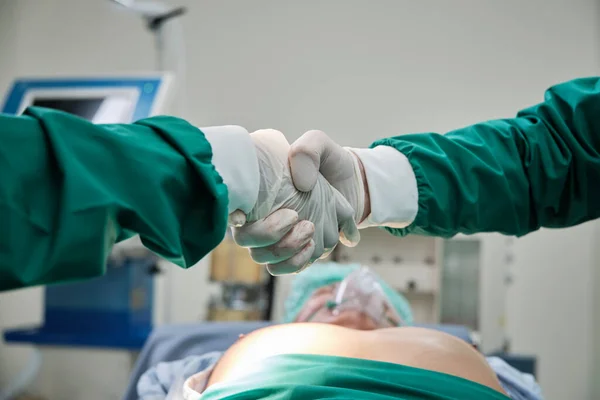 在医院的重症监护病房 两名外科专科医生在手术成功后 与重症监护病房的重症监护者握手 — 图库照片