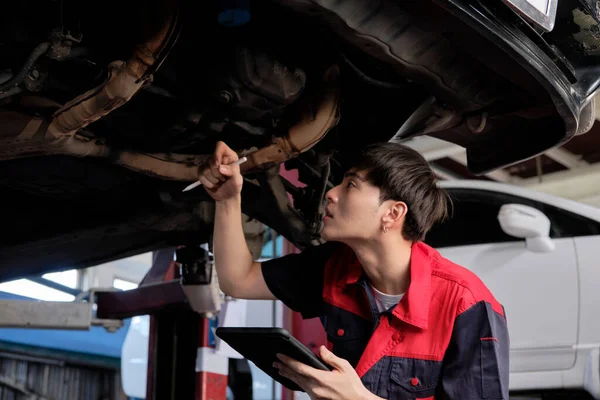 Professional Young Asian Male Motor Mechanic Inspects Undercarriage Electric Car — ストック写真