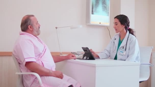 Egyenruhás Női Orvosok Magyarázatot Tanácsot Adnak Fehér Férfi Betegeknek Röntgen — Stock videók