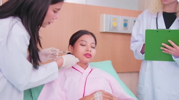 Asiatisk Kvinnelig Kosmetisk Lege Injiserer Botox Ansiktet Kvinnelig Pasient Ansiktspleie – stockvideo