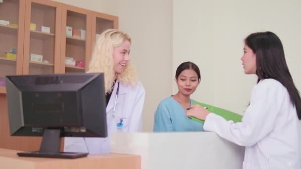 专业医疗人员小组 亚洲女医生和白药师在医院诊所药房柜台讨论了治疗药物处方 — 图库视频影像