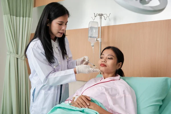 Asian female cosmetic doctor inject Botox into face of woman patient, face care, skin treatment, and young aging with body skincare at beauty clinic hospital, and cosmology medical.