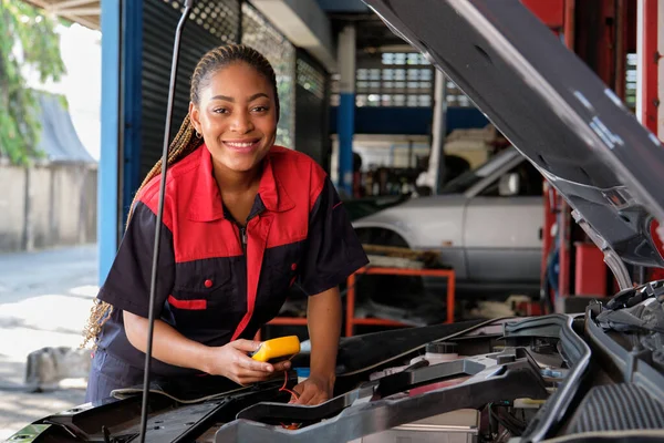One Black Female Professional Automotive Mechanical Worker Checks Car Battery 免版税图库图片