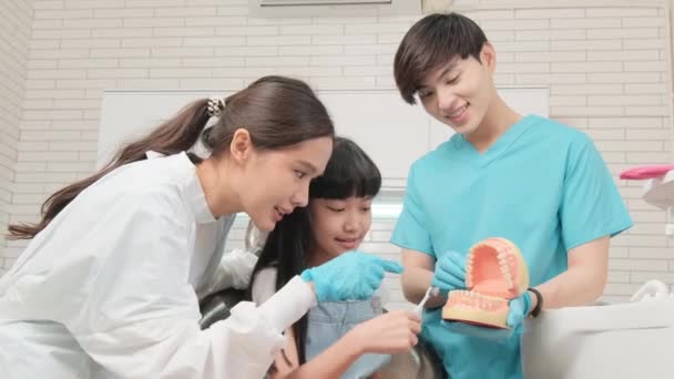 Odontóloga Asistente Pediátrica Asiática Demuestran Cepillo Dientes Niña Con Modelo — Vídeo de stock