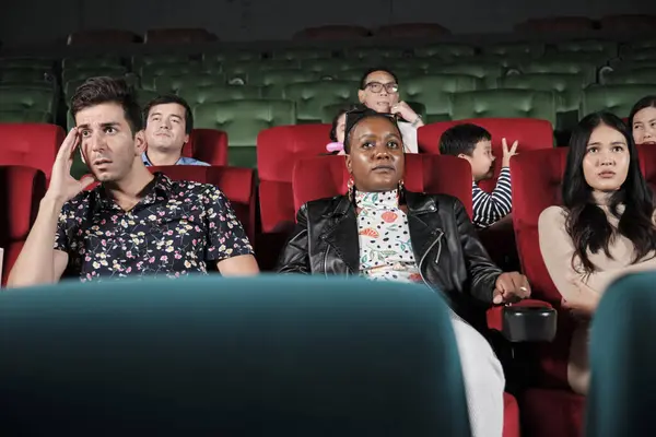 Various people in theater. Multiracial audiences, Black woman, and friends watching dramatic cinema and sad emotional expressions together on movie shows ending, entertainment lifestyle with film.