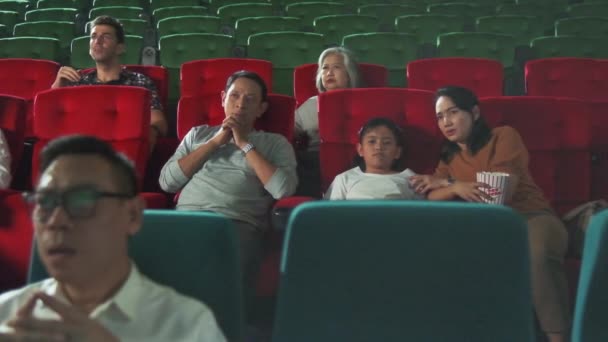劇場にはいろんな人がいる アジアの家族や多種多様な観客は スリラーやホラー映画を見ることを恐れ 映画の舞台で一緒に怖がり 映画アートショーでエンターテインメントライフスタイル — ストック動画