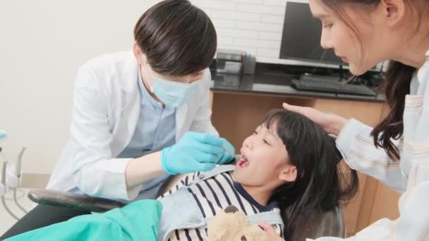 Dentista Pediátrico Masculino Asiático Revisa Examina Los Dientes Niña Con — Vídeo de stock