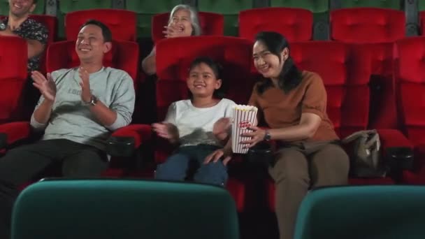 剧场里的很多人亚洲人的家庭 孩子和家长都喜欢看电影 喜欢在电影院里一起欢呼 喜欢以电影艺术节目来娱乐生活 喜欢开心的微笑 — 图库视频影像