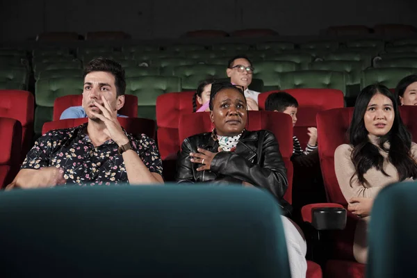 Various people in theater. Multiracial audiences, Black woman, and friends watching dramatic cinema and sad emotional expressions together on movie shows ending, entertainment lifestyle with film.