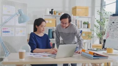 İki genç Asyalı şirket ortağı gündelik küçük işletme ofisinde tartışır ve beyin fırtınası yapar, bir dizüstü bilgisayarda pazarlama planlama işleri ve E-ticaret girişimcisi ve iş arkadaşı olarak serbest çalışma.