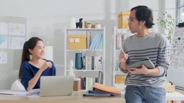 İki genç Asyalı şirket ortağı gündelik küçük işletme ofisinde tartışır ve beyin fırtınası yapar, bir dizüstü bilgisayarda pazarlama planlama işleri ve E-ticaret girişimcisi ve iş arkadaşı olarak serbest çalışma.