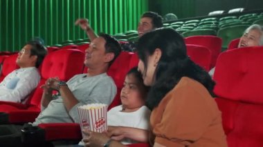 Asyalı aile izleyicileri sinemada birlikte sinema izlemekten hoşlanırlar. Çocuk ve ebeveynlerin kapalı bir eğlence hayatı var. Gösteri sanatları gösterileri var. Mutlu ve neşeli, patlamış mısır ve bir gülümseme..