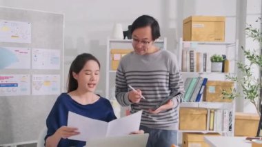 İki genç Asyalı şirket ortağı gündelik küçük işletme ofisinde tartışır ve beyin fırtınası yapar, bir dizüstü bilgisayarda pazarlama planlama işleri ve E-ticaret girişimcisi ve iş arkadaşı olarak serbest çalışma.