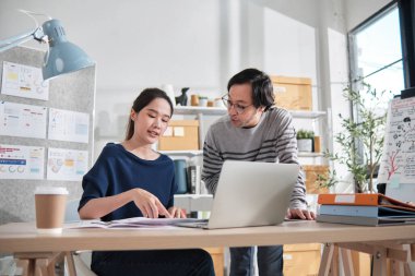 İki genç Asyalı şirket ortağı gündelik küçük işletme ofisinde tartışır ve beyin fırtınası yapar, bir dizüstü bilgisayarda pazarlama planlama işleri ve E-ticaret girişimcisi ve iş arkadaşı olarak serbest çalışma.