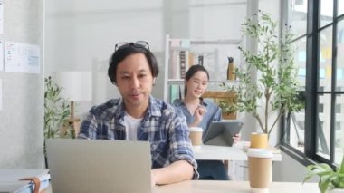 İki genç Asyalı girişim ortağı gündelik bir küçük işletme ofisinde çalışmaya, müşterilerle cep telefonuyla konuşmaya, dizüstü bilgisayarlı internet servis işleri ve E-ticaret KOBİ iş arkadaşı.