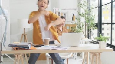 Sıradan bir küçük işletme ofisinde çalışmaktan mutluluk duyarım. İki Asyalı girişimci şirket iş arkadaşı birlikte dans etmekten ve şarkı söylemekten hoşlanırlar, serbest işlerden, mizahtan ve iş yerindeki komik iş arkadaşlarından dinlenirler..