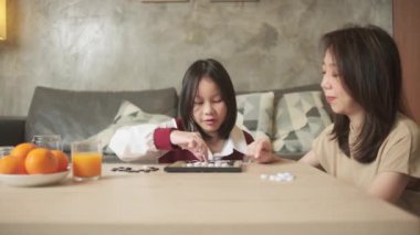 Asyalı aile, anne ve çocuk oyun oynuyorlar Go, dama masasında oyun oynuyorlar sevgi ve neşe dolu, çocuk ve ebeveynin rahatlatıcı hobisi, konsantre olup rekabet ediyorlar..